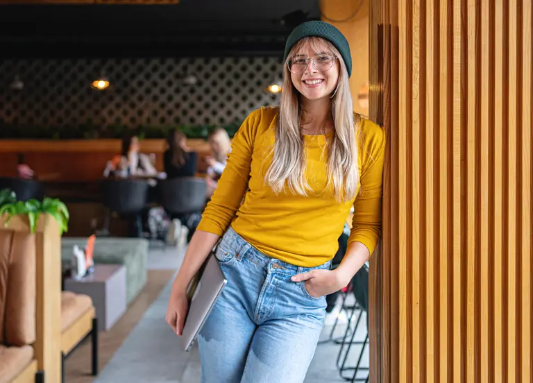 Urban young Caucasian woman holding a laptop