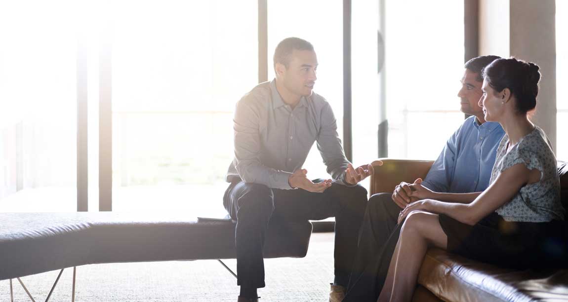 Young-businessman-talking-with-couple