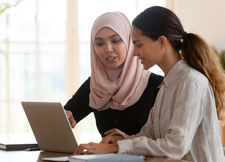 Two people looking at a laptop